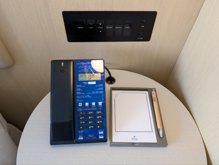 ベッドサイド。スイッチ・コンセント・電話機・メモ。